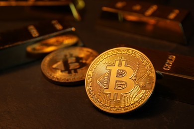 Photo of Cryptocurrency. Golden bitcoins and gold bars on black table, closeup
