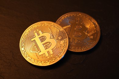 Photo of Cryptocurrency. Golden bitcoin on black table, closeup