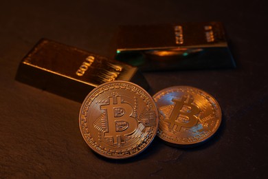 Photo of Cryptocurrency. Golden bitcoins and gold bars on black table, closeup