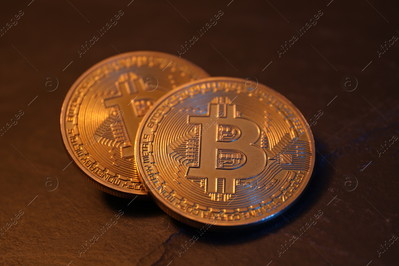 Photo of Cryptocurrency. Golden bitcoin on black table, closeup