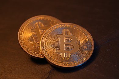 Photo of Cryptocurrency. Golden bitcoin on black table, closeup