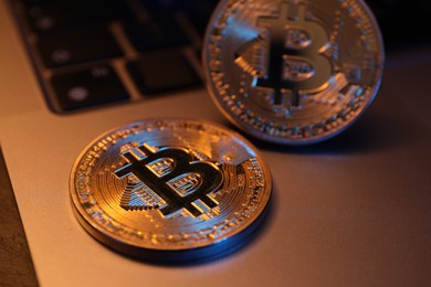 Photo of Cryptocurrency. Silver bitcoins and laptop on table, closeup