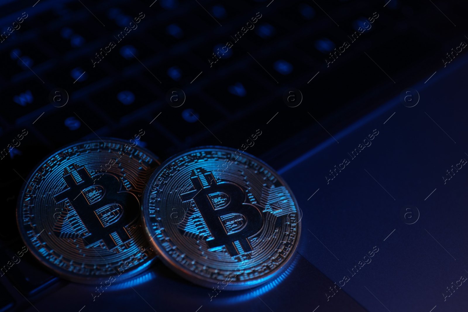 Photo of Cryptocurrency. Silver bitcoins on laptop, closeup. Space for text