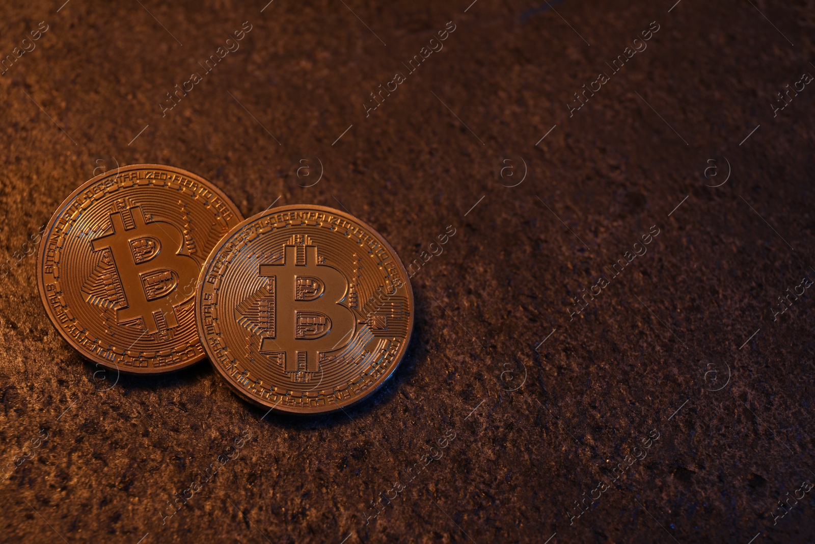 Photo of Cryptocurrency. Golden bitcoins on black table, top view. Space for text