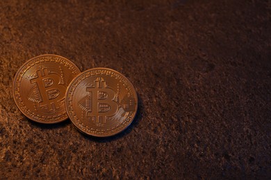 Photo of Cryptocurrency. Golden bitcoins on black table, top view. Space for text