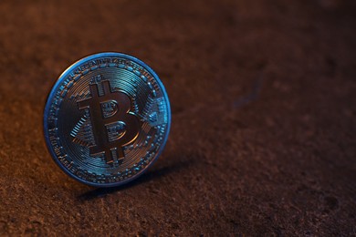 Photo of Cryptocurrency. One silver bitcoin on black table, closeup. Space for text