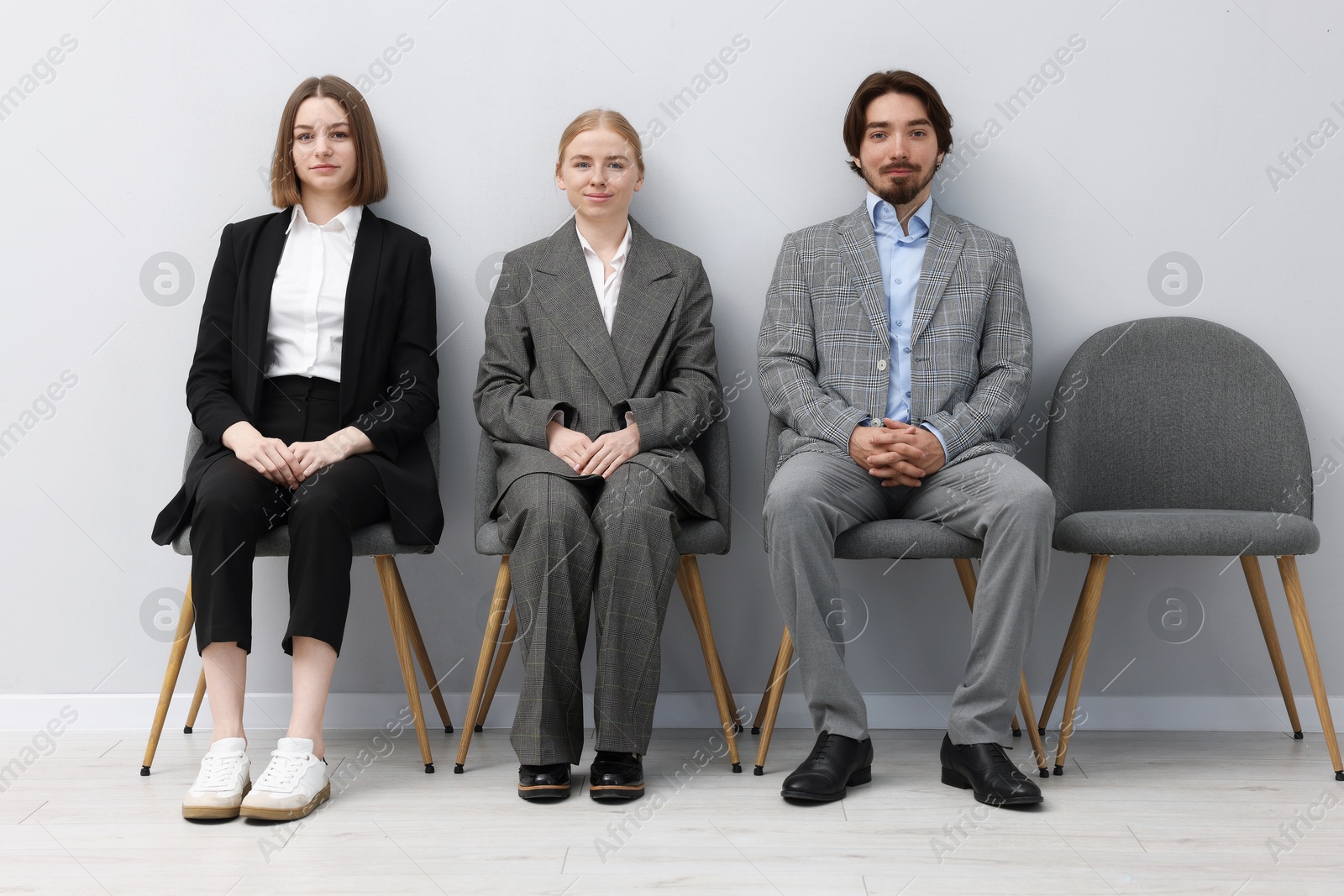 People waiting in queue on chairs indoors Photo of People waiting in queue on chairs indoors