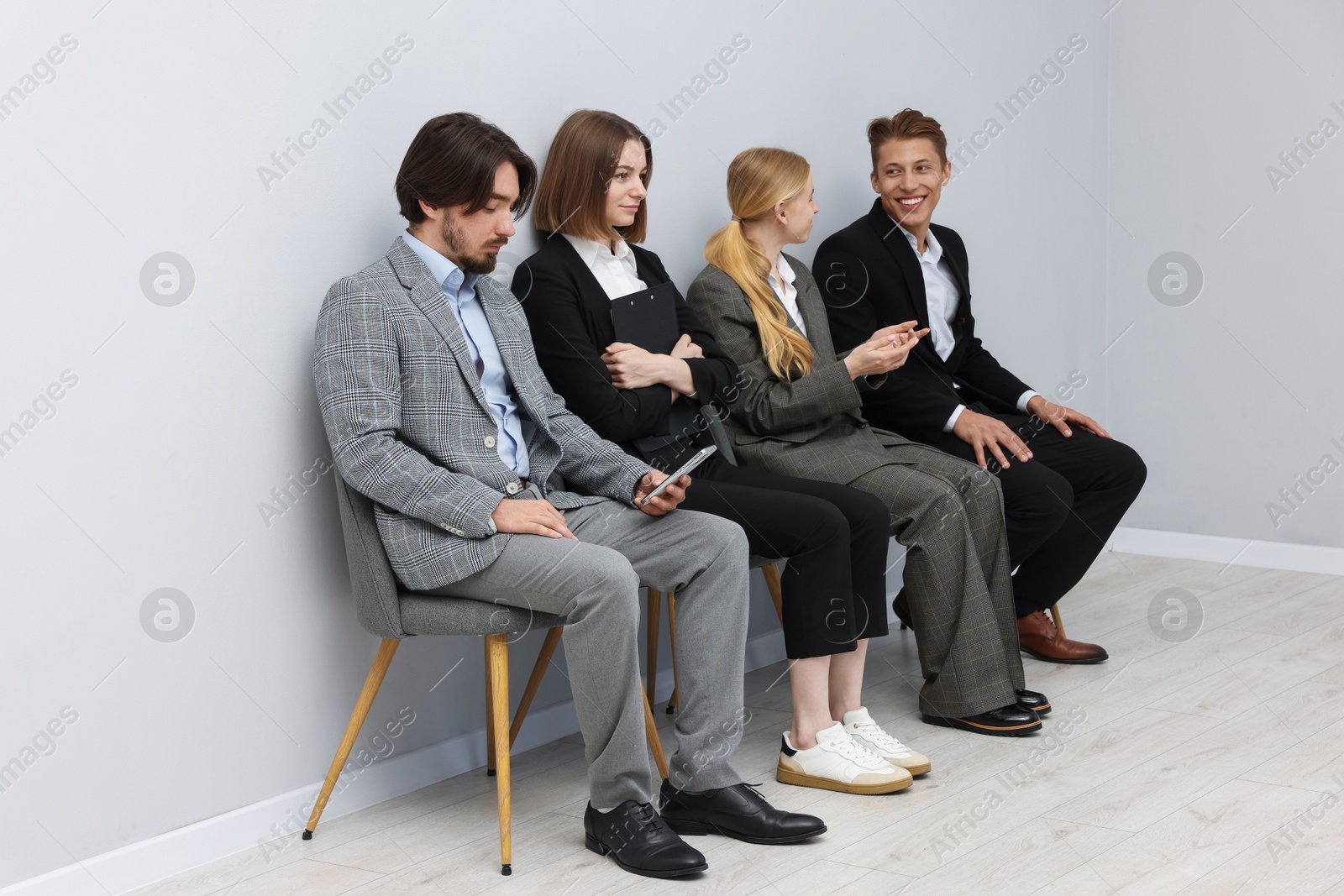 People waiting in queue on chairs indoors Photo of People waiting in queue on chairs indoors