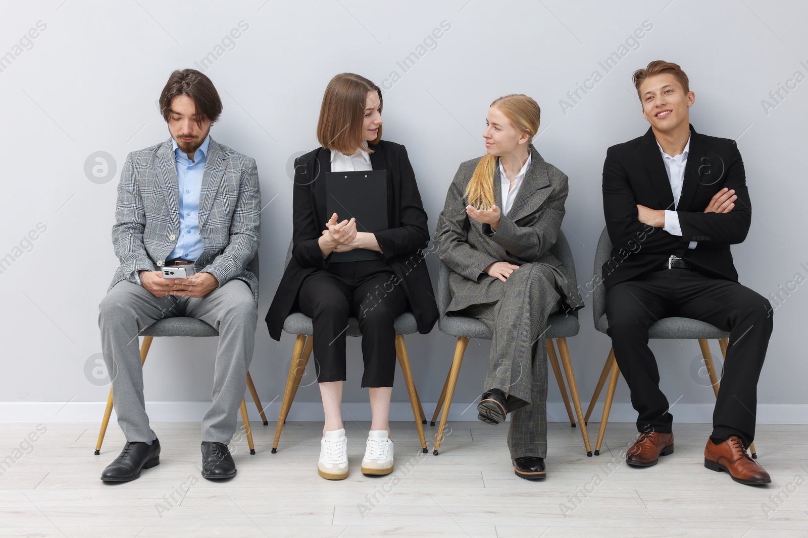 People waiting in queue on chairs indoors Photo of People waiting in queue on chairs indoors