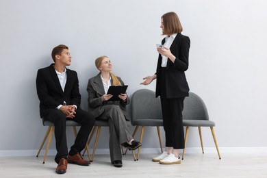 Photo of People waiting in queue on chairs indoors