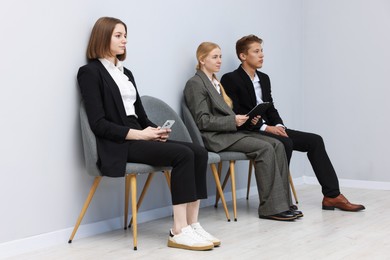 Photo of People waiting in queue on chairs indoors