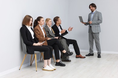 Photo of People waiting in queue on chairs indoors
