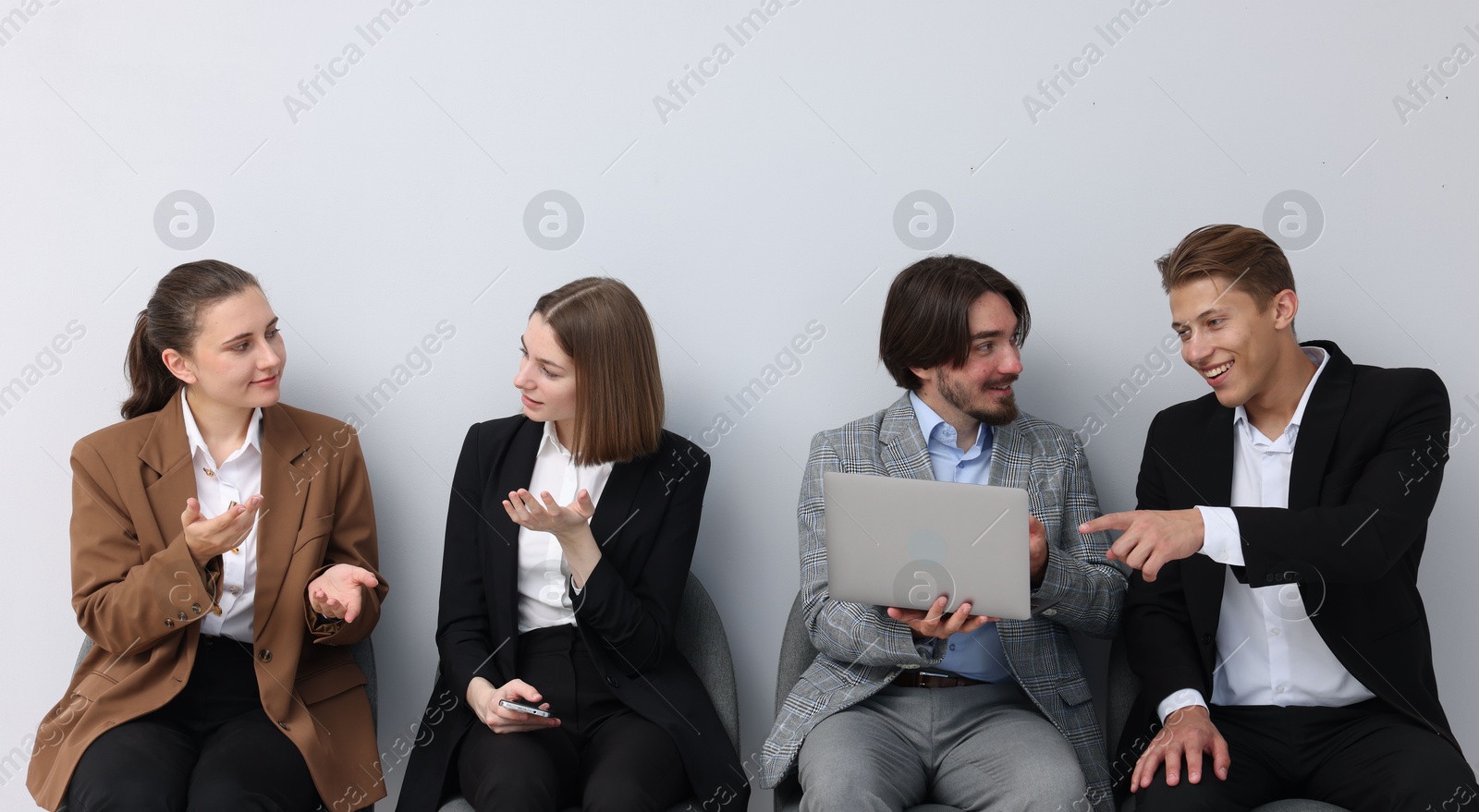 People waiting in queue on chairs indoors Photo of People waiting in queue on chairs indoors