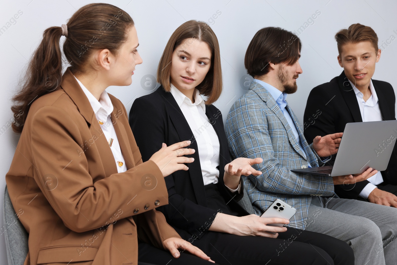 People waiting in queue on chairs indoors Photo of People waiting in queue on chairs indoors