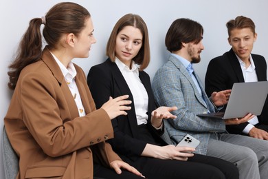 Photo of People waiting in queue on chairs indoors