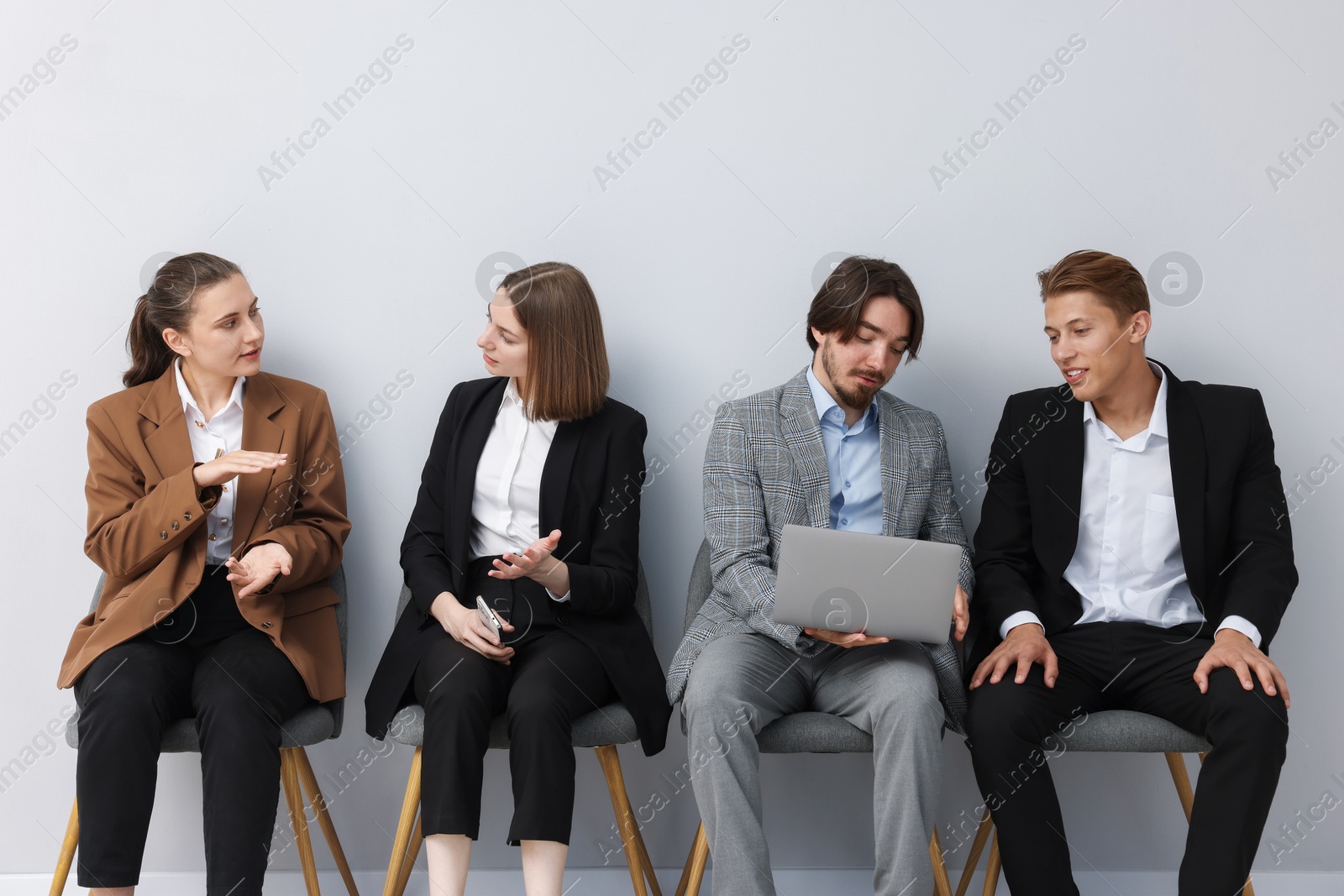 People waiting in queue on chairs indoors Photo of People waiting in queue on chairs indoors