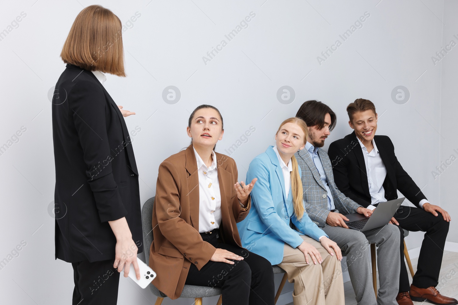 People waiting in queue on chairs indoors Photo of People waiting in queue on chairs indoors