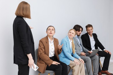 Photo of People waiting in queue on chairs indoors