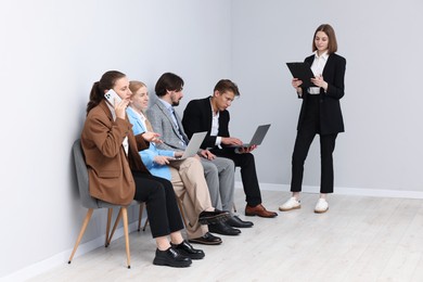 Photo of People waiting in queue on chairs indoors