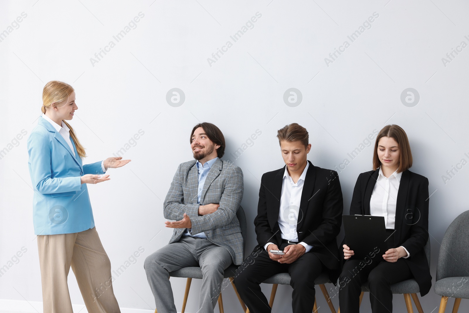 People waiting in queue on chairs indoors Photo of People waiting in queue on chairs indoors