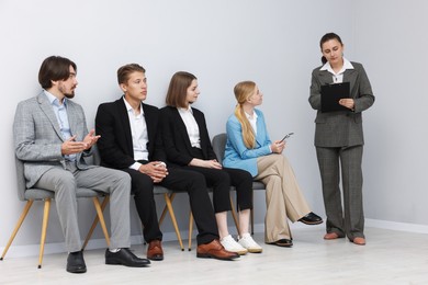 Photo of People waiting in queue on chairs indoors