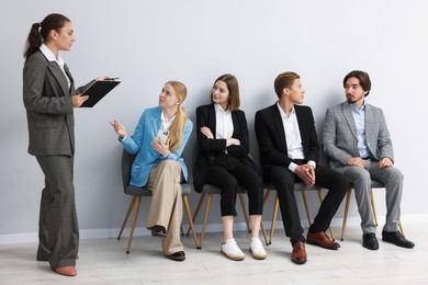 Photo of People waiting in queue on chairs indoors