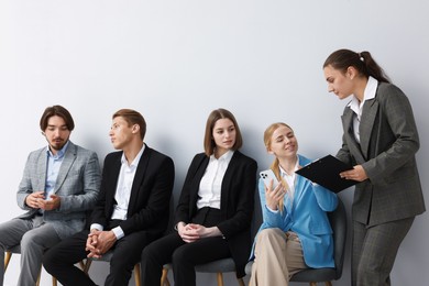 Photo of People waiting in queue on chairs indoors