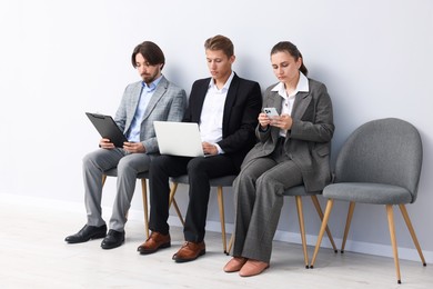 Photo of People waiting in queue on chairs indoors