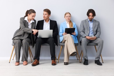 Photo of People waiting in queue on chairs indoors