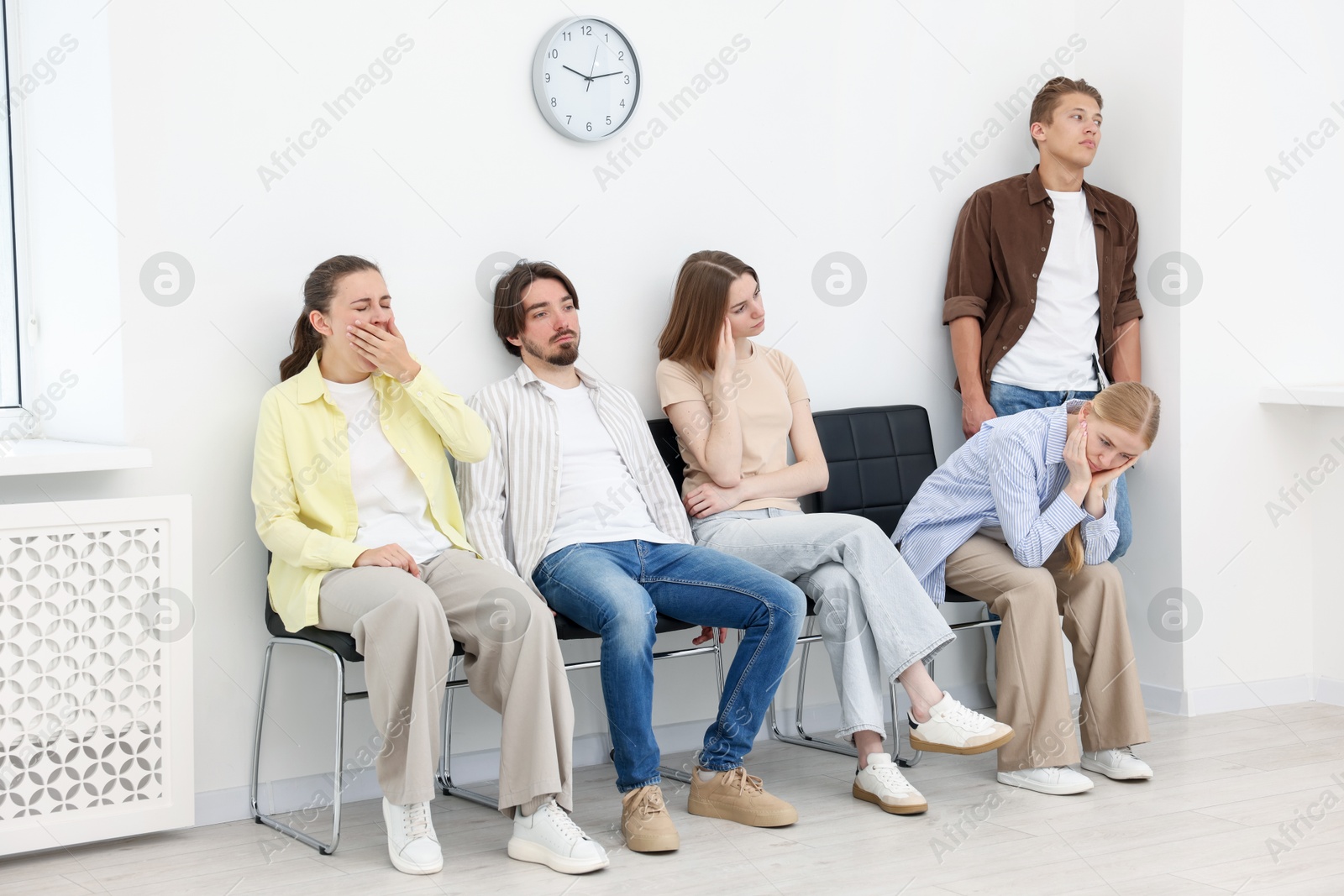 People waiting in queue on chairs indoors Photo of People waiting in queue on chairs indoors