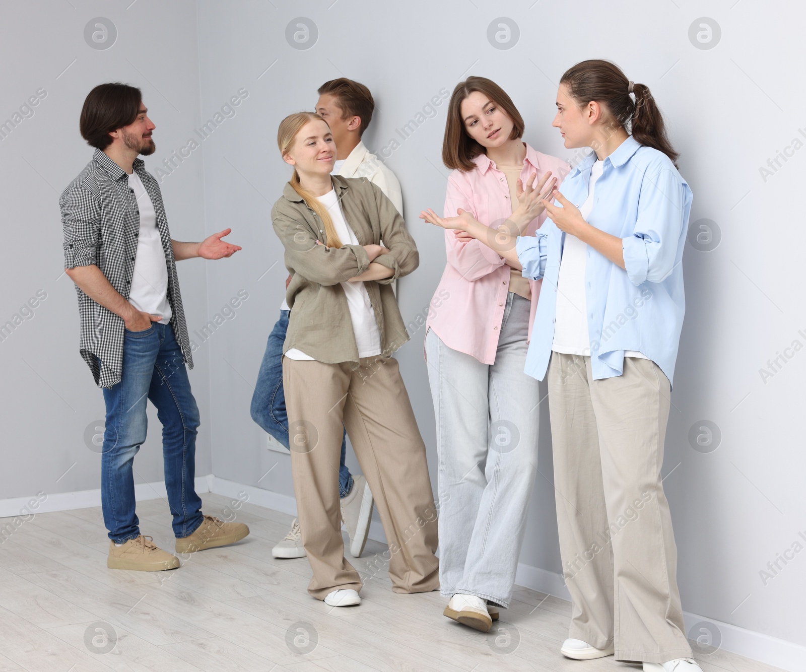 Group of people waiting in queue near light grey wall indoors Photo of Group of people waiting in queue near light grey wall indoors