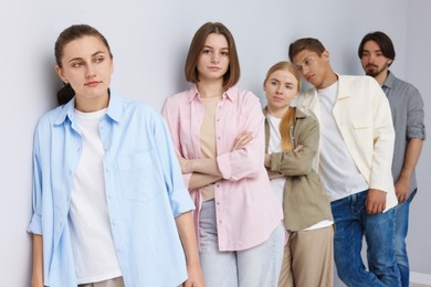 Photo of Group of people waiting in queue near light grey wall indoors