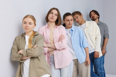 Photo of Group of people waiting in queue near light grey wall indoors