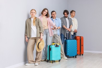 Photo of Group of people with luggages waiting in queue indoors