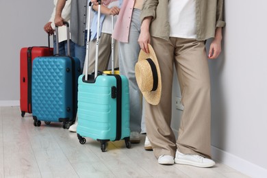 Photo of Group of people with luggages waiting in queue indoors, closeup