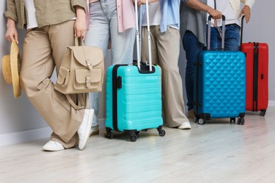 Photo of Group of people with luggages waiting in queue indoors, closeup