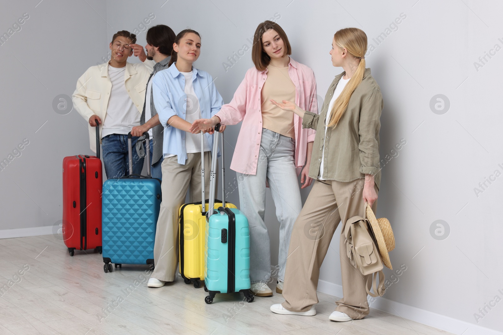 Group of people with luggages waiting in queue indoors Photo of Group of people with luggages waiting in queue indoors