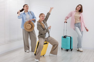 Photo of People with luggages having fun while waiting in queue indoors