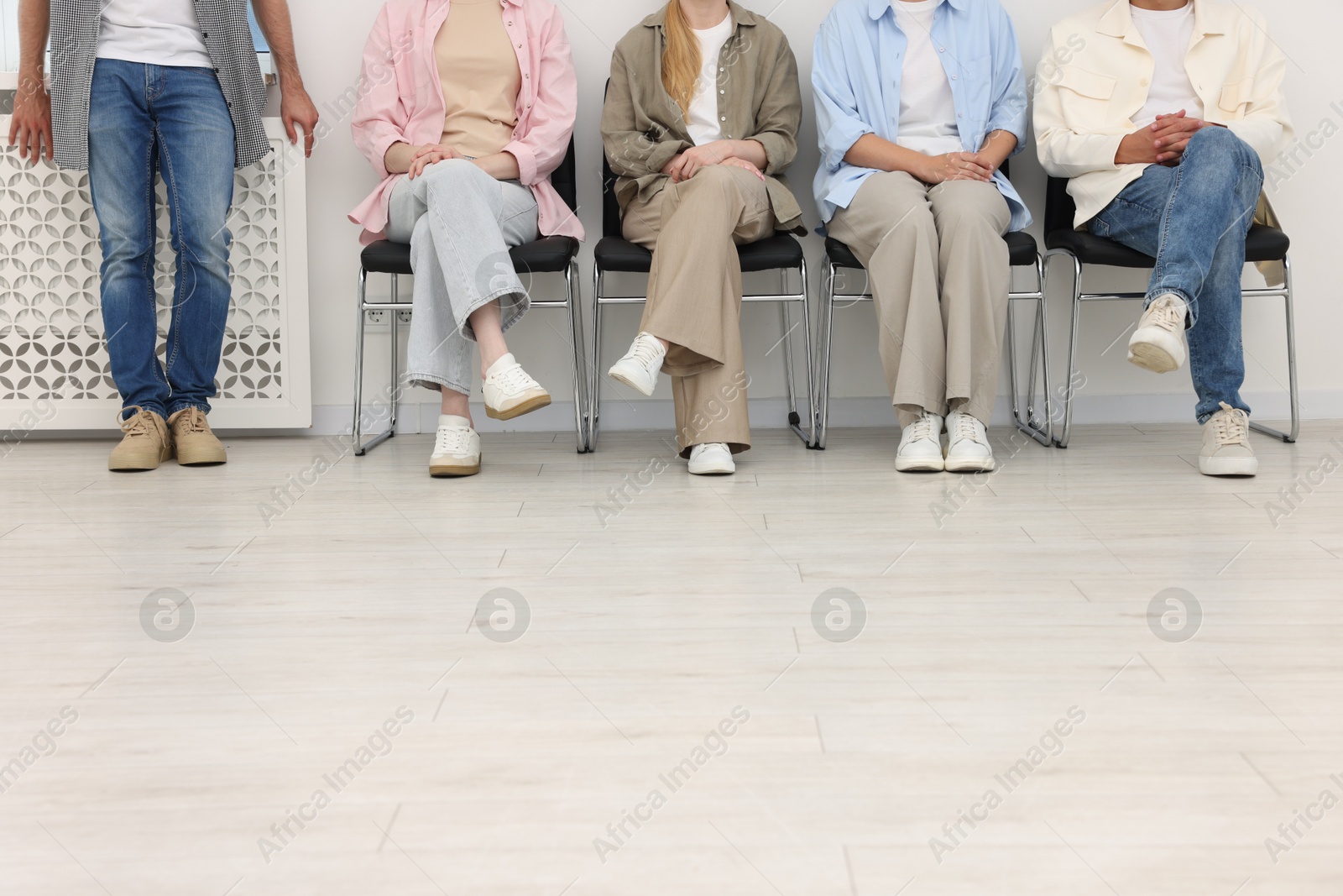 People waiting in queue on chairs indoors, closeup Photo of People waiting in queue on chairs indoors, closeup