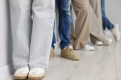 Photo of Group of people waiting in queue indoors, closeup