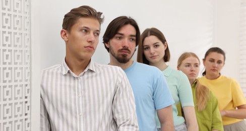 Photo of Group of people waiting in queue indoors