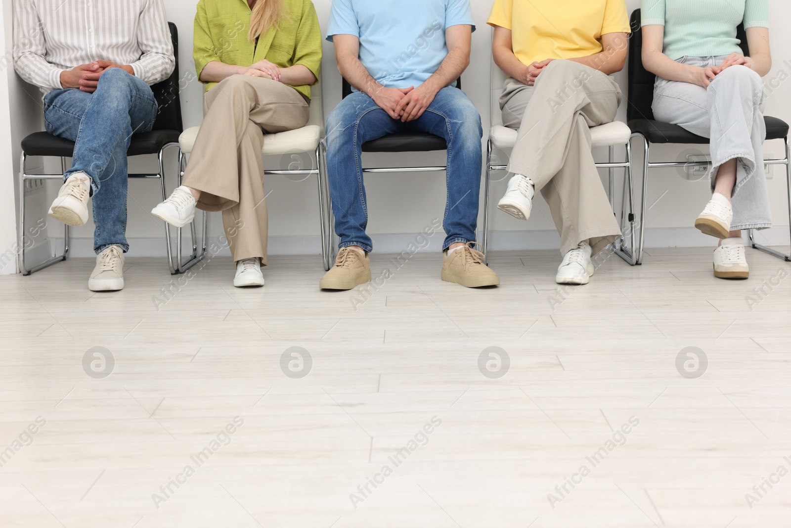 People waiting in queue on chairs indoors, closeup Photo of People waiting in queue on chairs indoors, closeup