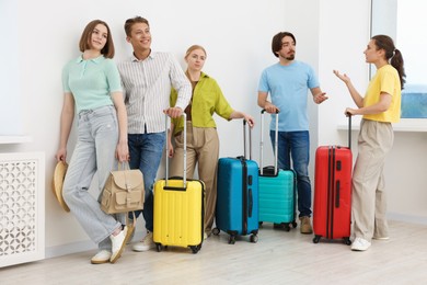 Photo of People with luggages waiting in queue indoors