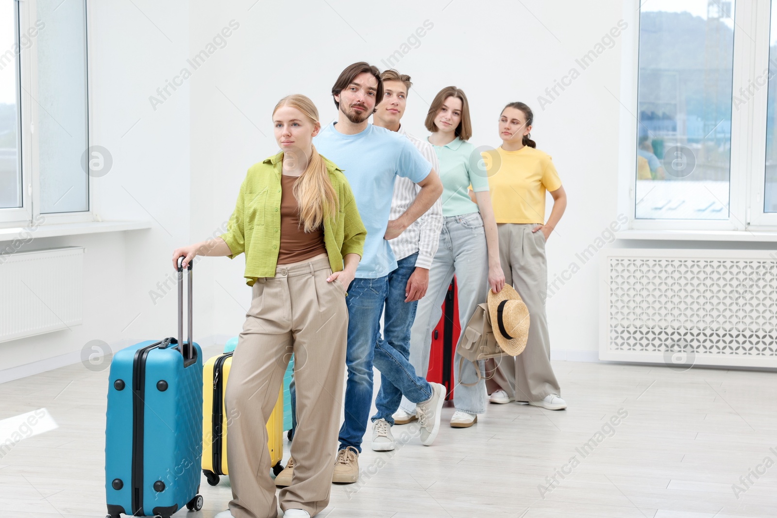 People with luggages waiting in queue indoors Photo of People with luggages waiting in queue indoors