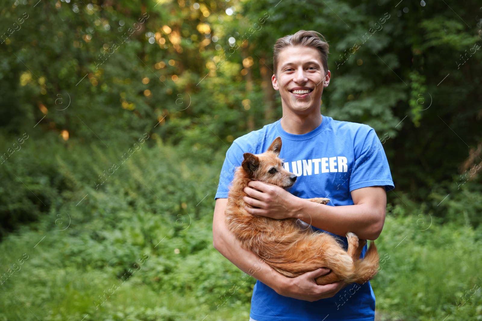 Photo of Volunteer with cute stray dog outdoors, space for text