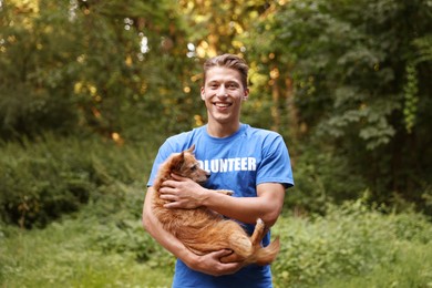 Photo of Volunteer with cute stray dog outdoors. Animal rescue