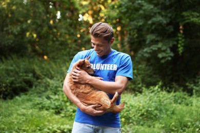 Photo of Volunteer with cute stray dog outdoors. Animal rescue