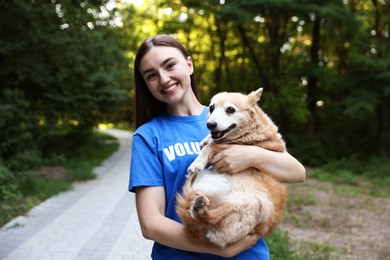 Photo of Volunteer with cute stray dog outdoors. Animal rescue