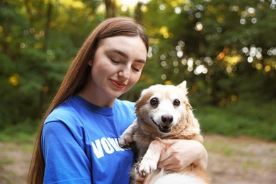 Photo of Volunteer with cute stray dog outdoors. Animal rescue