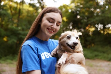 Photo of Volunteer with cute stray dog outdoors. Animal rescue